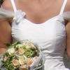 Detail - ausgestelltes Brautkleid mit kleiner Schleppe, verziert mit Blüten und Tüll. Dazu passend gefertigtes Ringkissen und Brautbeutel mit Blümchen verziert.